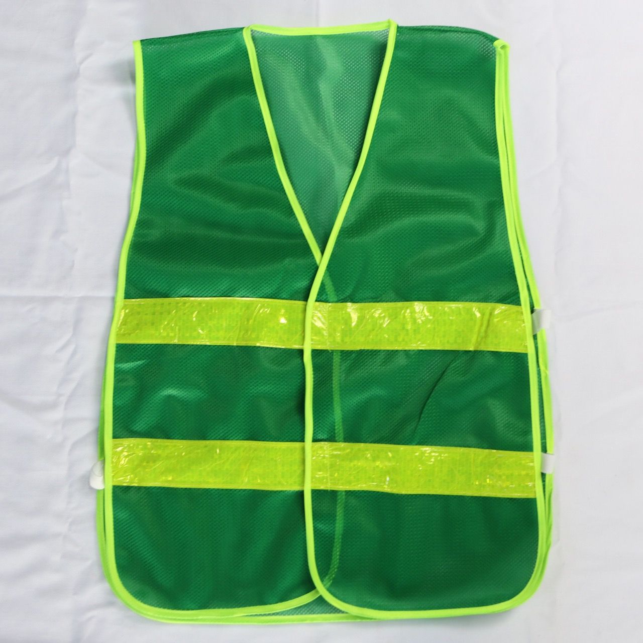 Green reflective mesh vest with elastic sides, featuring banana-checkered plastic reflective material