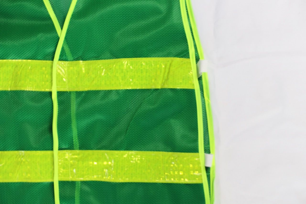 Green reflective mesh vest with elastic sides, featuring banana-checkered plastic reflective material
